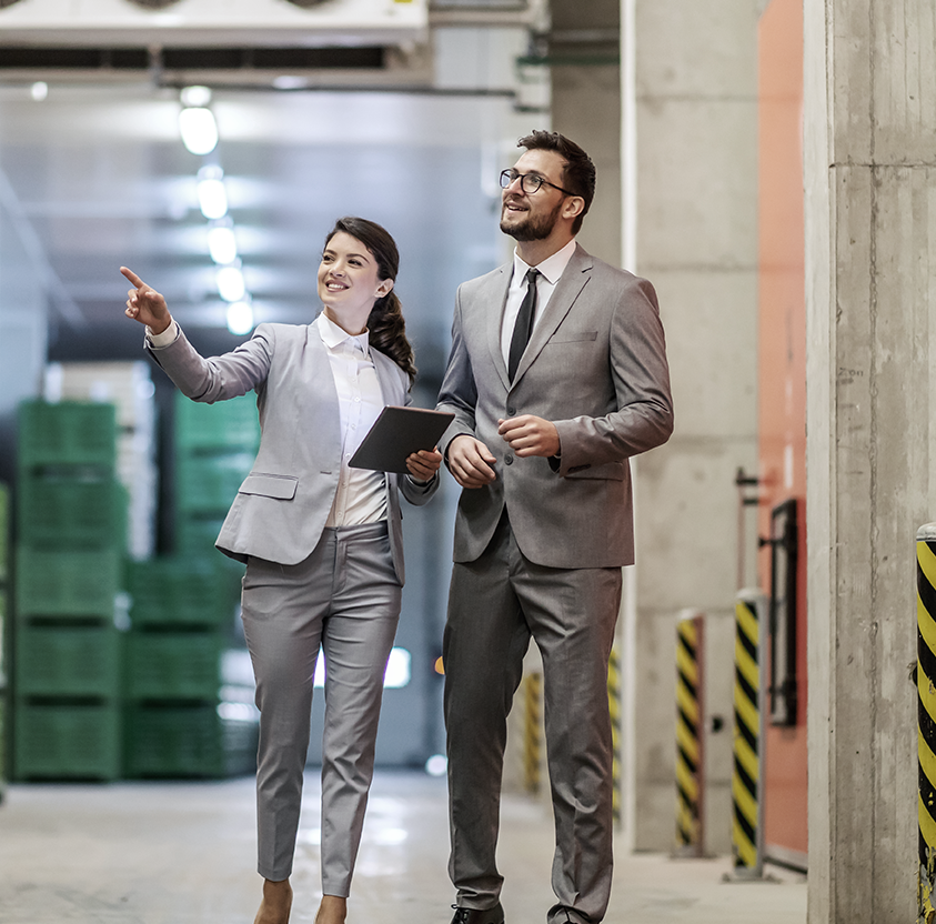 Business people warehouse man woman dressed modern suit walk throw warehouse
