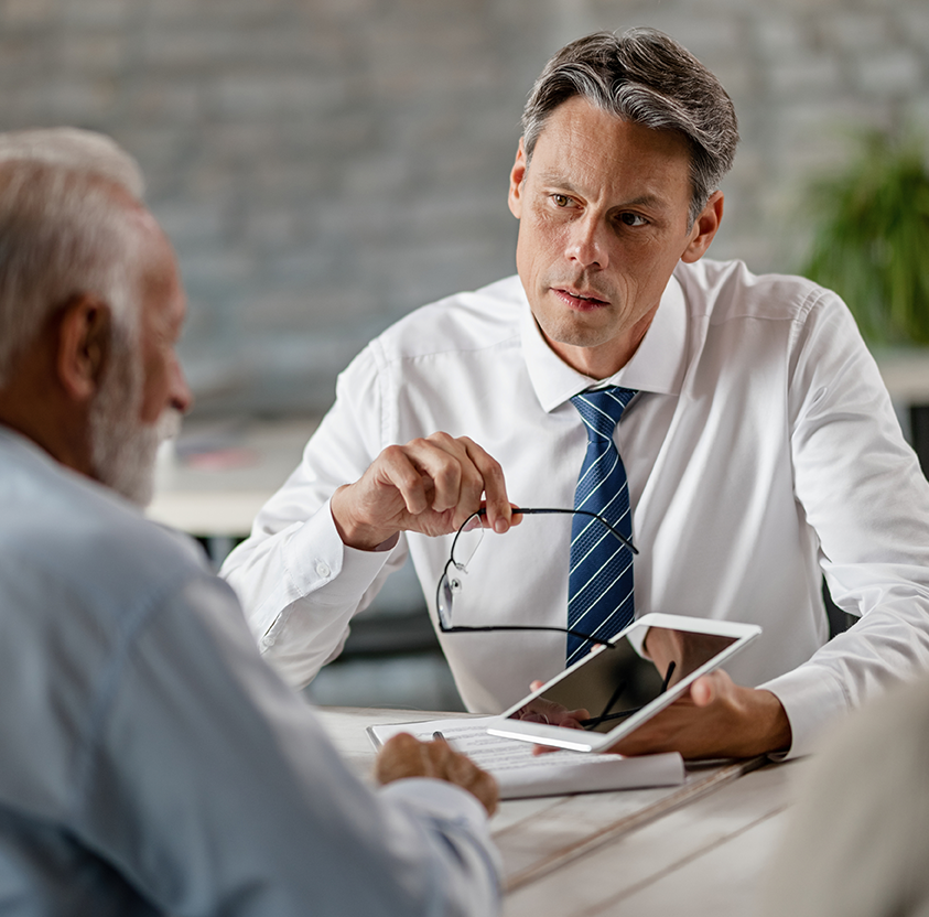 Insurance agent communicating with senior clients while showing something touchpad meeting