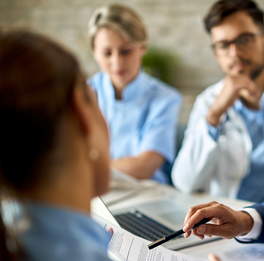 Mid adult businessman healthcare workers analyzing documents meeting office