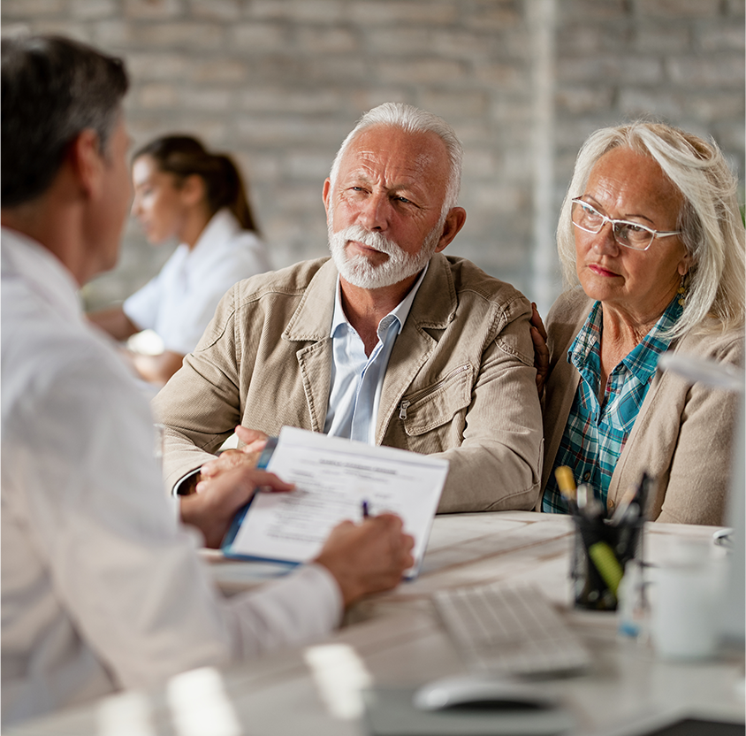 Senior couple consulting with healthcare worker about their insurance policy while