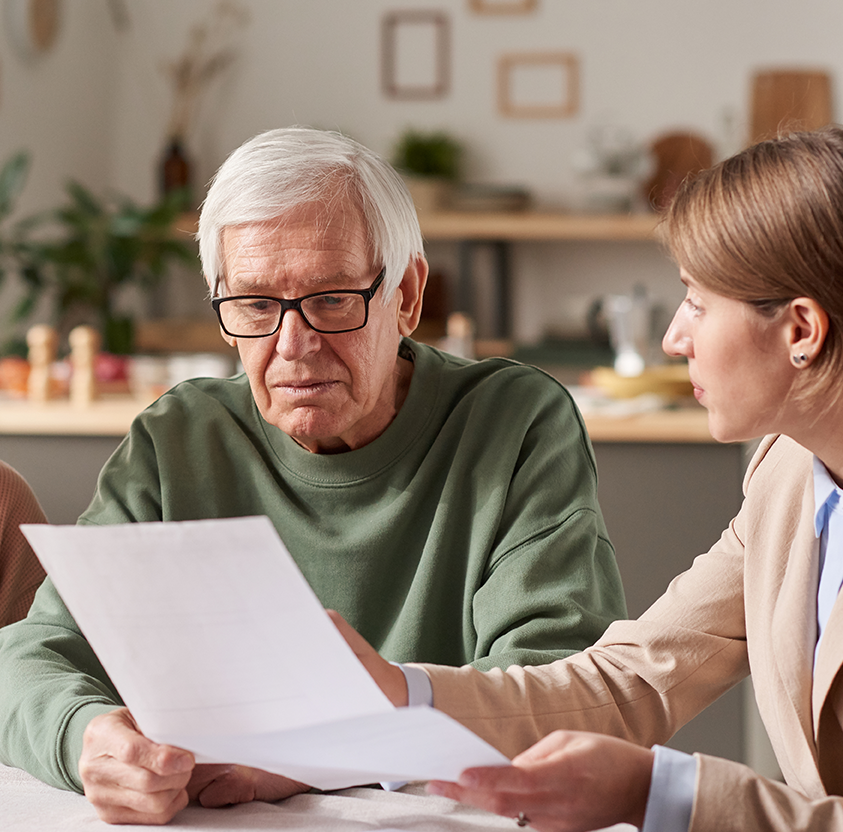 Senior couple sitting table discussing documents with real estate agent they
